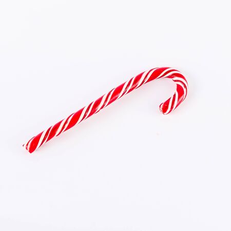 one red Christmas candy with fir twig on white backgroundの写真素材