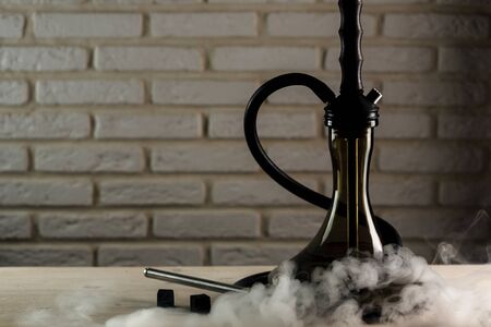wooden hookah on a white wooden table on brick wall backgroundの写真素材