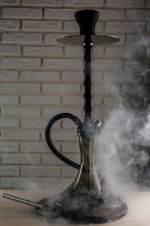 wooden hookah on a white wooden table on brick wall backgroundの写真素材