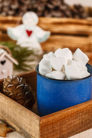 Marshmallows in blue mug in brown wooden box with ginger cookieの写真素材