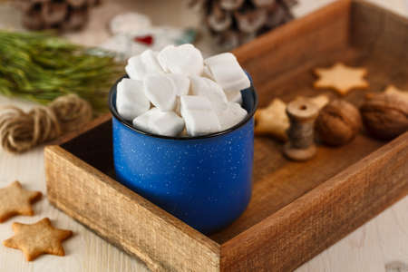 Marshmallows in blue mug in brown wooden box with ginger cookieの写真素材