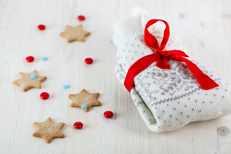 White christmas slippers or socks on a white wooden table with gingerbread and candiesの写真素材