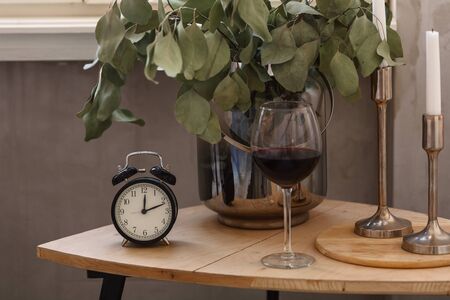 morning. Bedside table. Home decor. Wine glass Clock closeupの写真素材
