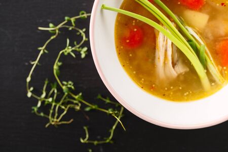 homemade chicken soup in white plate on black backgroundの写真素材