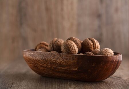 whole walnuts on rustic old wooden tableの写真素材
