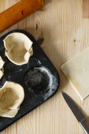 raw dough in a baking dish. Closeup. Top view. On wooden table. Copyspaceの写真素材