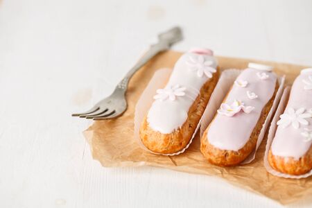 Traditional french eclairs on white table with pink flower. Copyspaceの写真素材