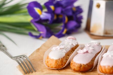 Traditional French eclairs with coffee. Good Breakfast. Decorated Iris flowersの写真素材