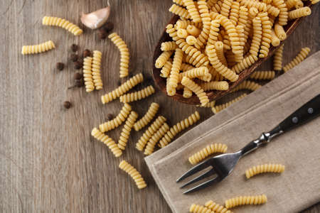 Italian raw pasta fusilli on the background of other ingredients for cooking. Top viewの写真素材