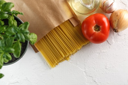 raw italian pasta spaghetti with vegetables on white background. Top view. Copyspaceの写真素材