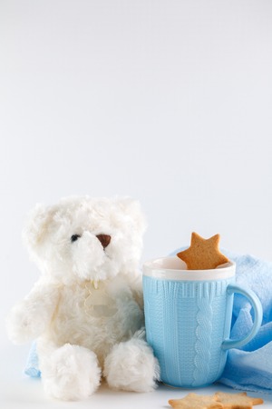 White Teddy bear, blue mug and cookies on white background. Christmas compositionの写真素材