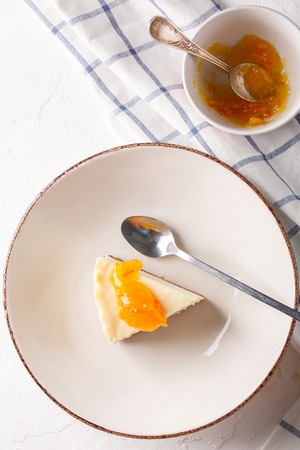 cheesecake with orange jam in a plate on a white background. Flatlay. Top viewの写真素材