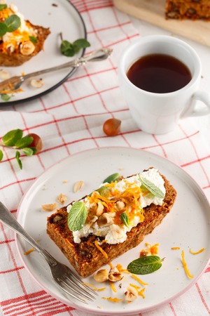 carrot fruit cake, with nuts, cream and mint on white backgroundの写真素材