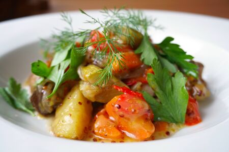 grilled vegetable salad with honey, mustard and herbs on white plateの写真素材