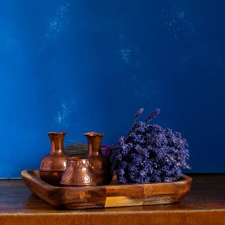 Still-life. Lavender bouquet and mini copper tableware on a blue backgroundの写真素材