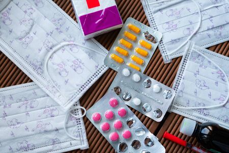 Coronavirus. Unused medical masks and medications on a wooden tableの写真素材
