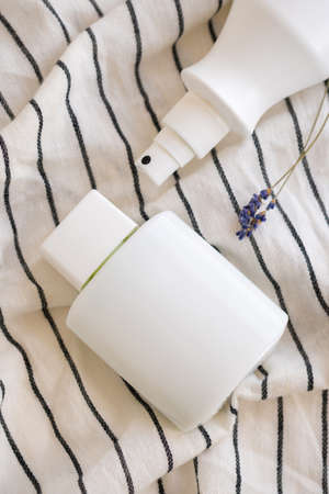 white cosmetic bottles on a textile background. Content.