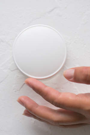 A womans hand with a jar of face cream on a white background. The concept of cosmetics.