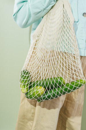 cucumbers in a shopping bag that hangs on a girl's shoulderの写真素材