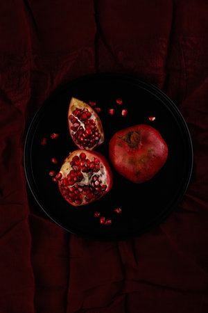 Pomegranate. Parts of a whole Pomegranate on a dark background.の写真素材
