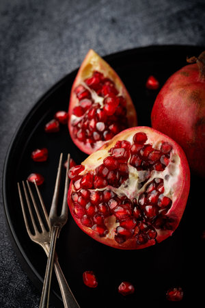 Pomegranate. Parts of a whole Pomegranate on a dark background.の写真素材