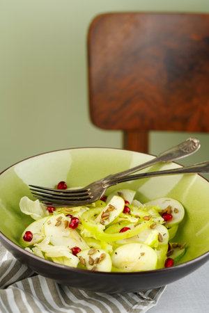 Green salad with fresh vegetables and fruits. Salad of green apple and green peppers with pomegranate seeds in a green plate.の写真素材