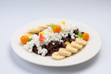 Breakfast. Rustic cheese with granola and fruits on a white plate and a white background