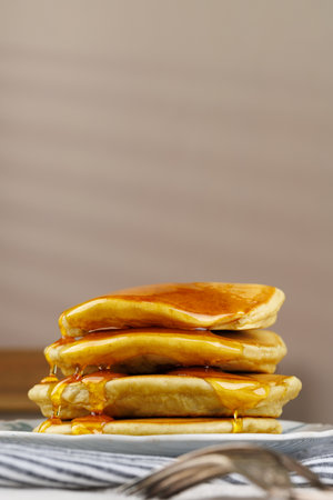 A stack of pancakes with honey on a vintage plate on the table. Breakfast.の写真素材