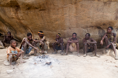 hadzabe men sitting around a fire in a village of tanzaniaのeditorial素材