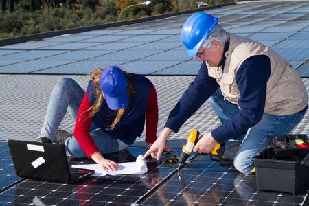 young engineer girl and an elderly skilled worker fitting a photovoltaic plant