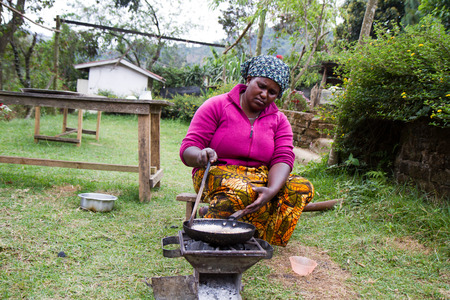 woman roasting coffee in a traditional way in arusha tanzaniaのeditorial素材