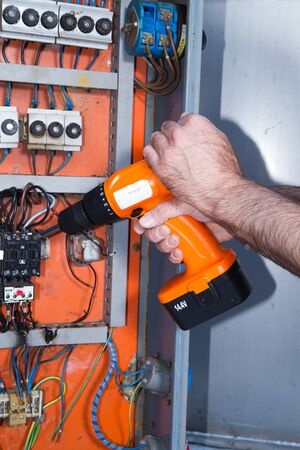 electrician at work with an electric panelの写真素材