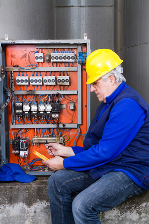 electrician at work with an electric panelの写真素材