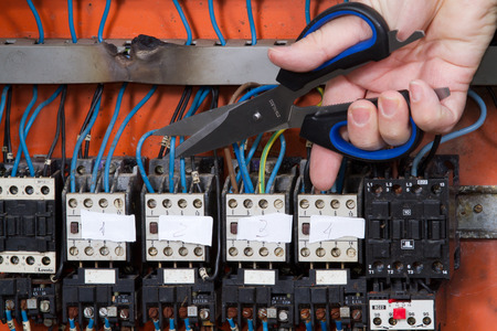 electrician at work with an electric panelの写真素材