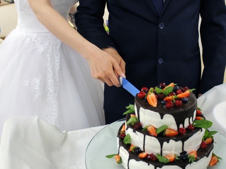 The bride and groom cut the wedding cake.の写真素材