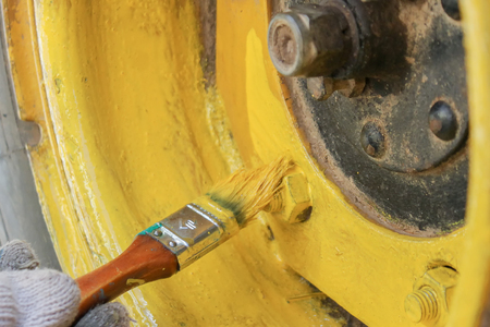The wheel of the all-terrain vehicle is painted in yellow with a brushの写真素材