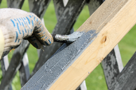 The process of painting a wooden coating with a brush with gray paintの写真素材