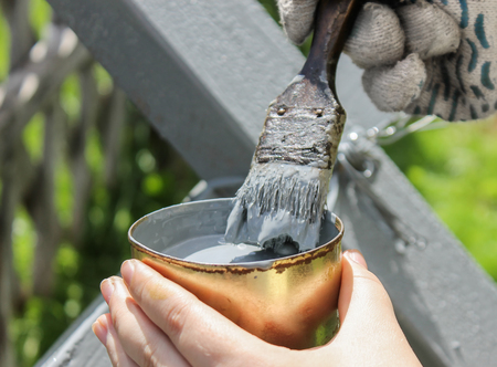 Brush dipped in a can with gray paintの写真素材