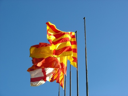 Barcelona,Spain and Catalonia flags over blue skyの写真素材