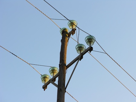 Electric posts over blue sky, detail