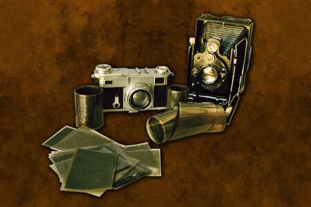 A very old camera (from the beginning of the XXth century) set with an old album , old photographs and some film over a retro background. Effects made like it it was a really old photographyの写真素材
