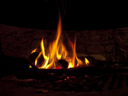 Warming fireplace in winter, at home. Close up of flames and firewoodの写真素材