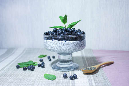 pudding with chia seeds and juicy blueberries, garnished with a sprig of fresh mint.の写真素材