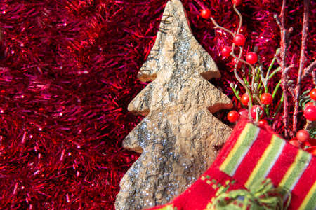 Festive Christmas background with a tree bark Christmas tree on a festive red tinsel backgroundの写真素材