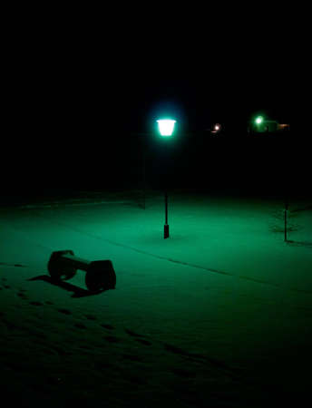 Light from lantern illuminates bench in the park.の写真素材