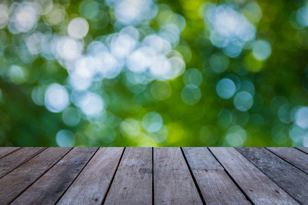 Wood plank with abstract natural green blurred bokeh background for product displayの写真素材