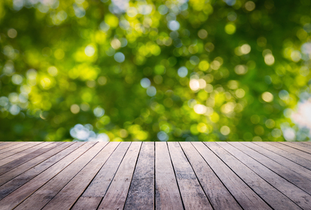 Wood plank with abstract natural green blurred bokeh background for product displayの写真素材