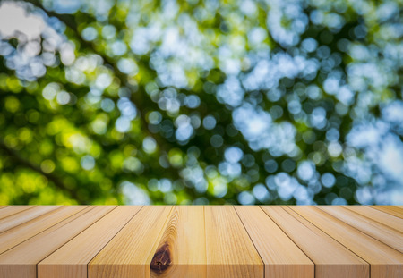 Wood plank with abstract natural green blurred bokeh background for product displayの写真素材