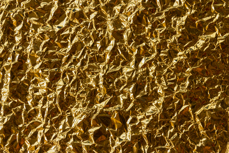 Crumpled gold foil texture backgroundの写真素材