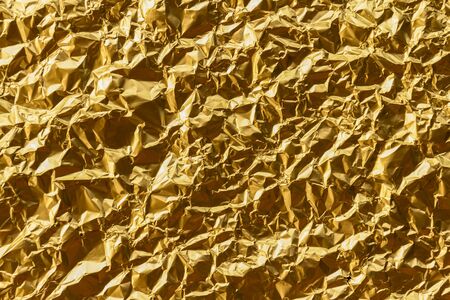 Crumpled gold foil texture backgroundの写真素材